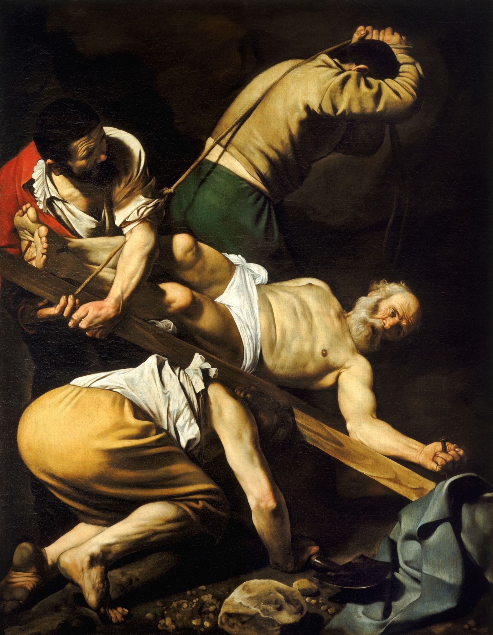 Three workers lift the cross of an upside-down Peter, pulling a rope, raising the wood, and bracing beneath it.
