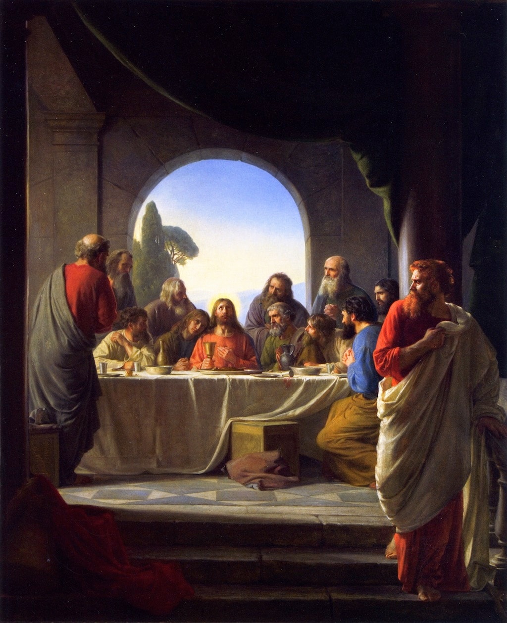 Jesus holds a cup at a table surrounded by disciples, while a red-haired figure stands in the foreground.