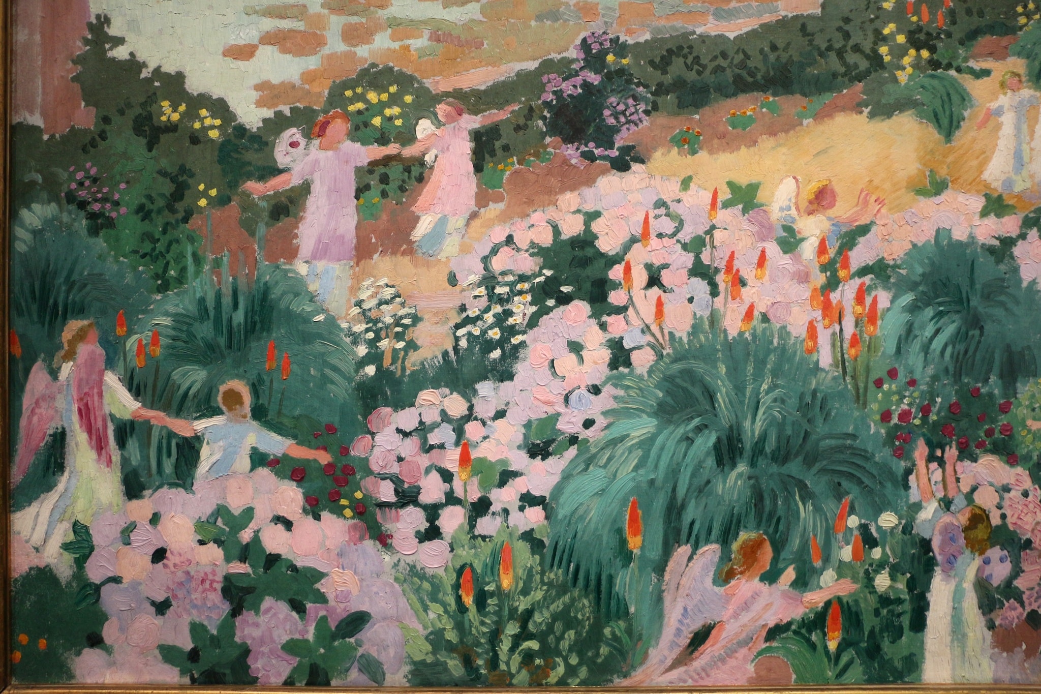 Winged figures and children join hands among pink flowers and dark green foliage in Maurice Denis’s Le Paradis.