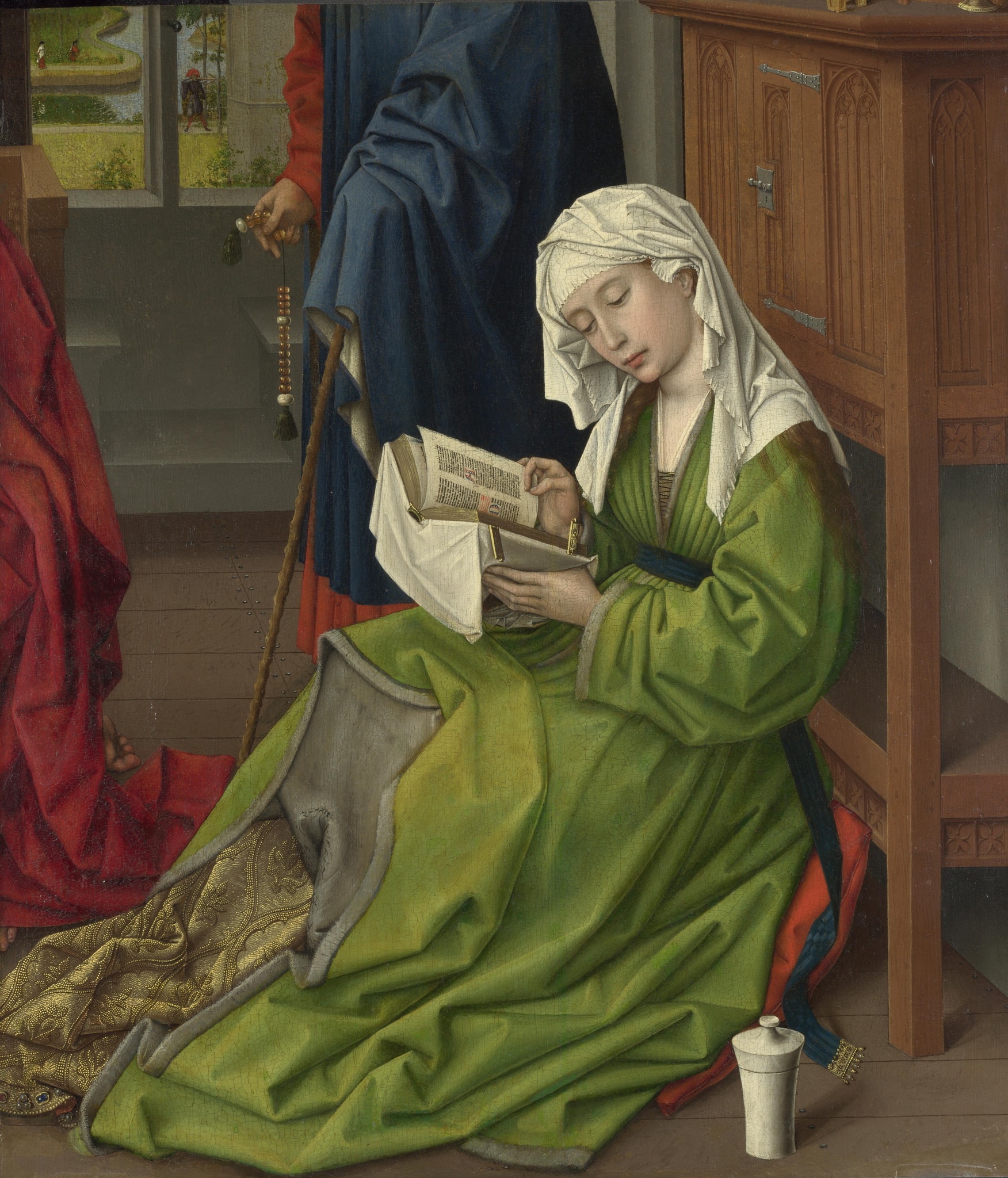 A white-veiled Mary Magdalene in a green gown bends over an open book, with an ointment jar beside her and fragments of other figures nearby.