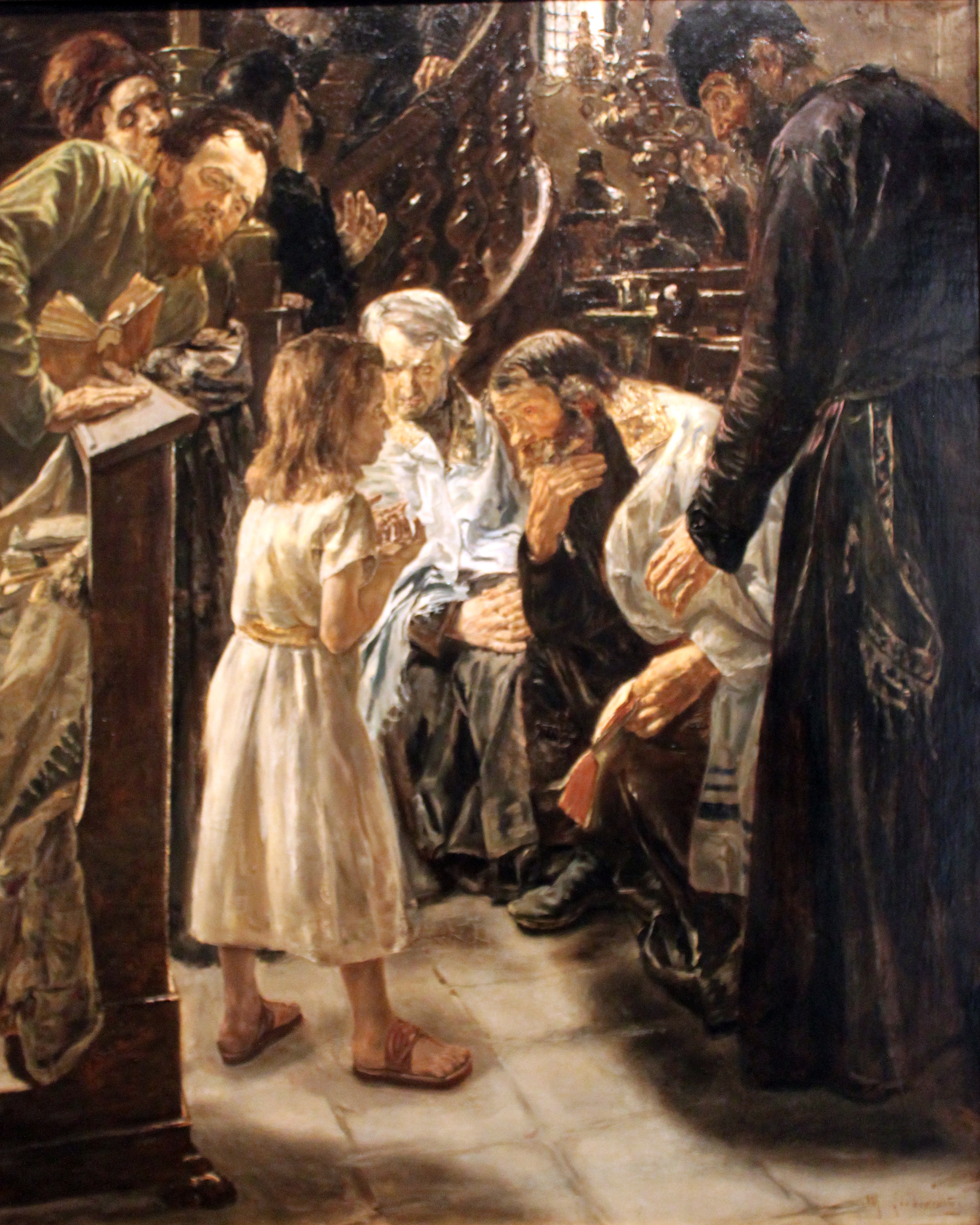 A boy in a pale tunic stands among older men who lean toward him and listen in a crowded interior.