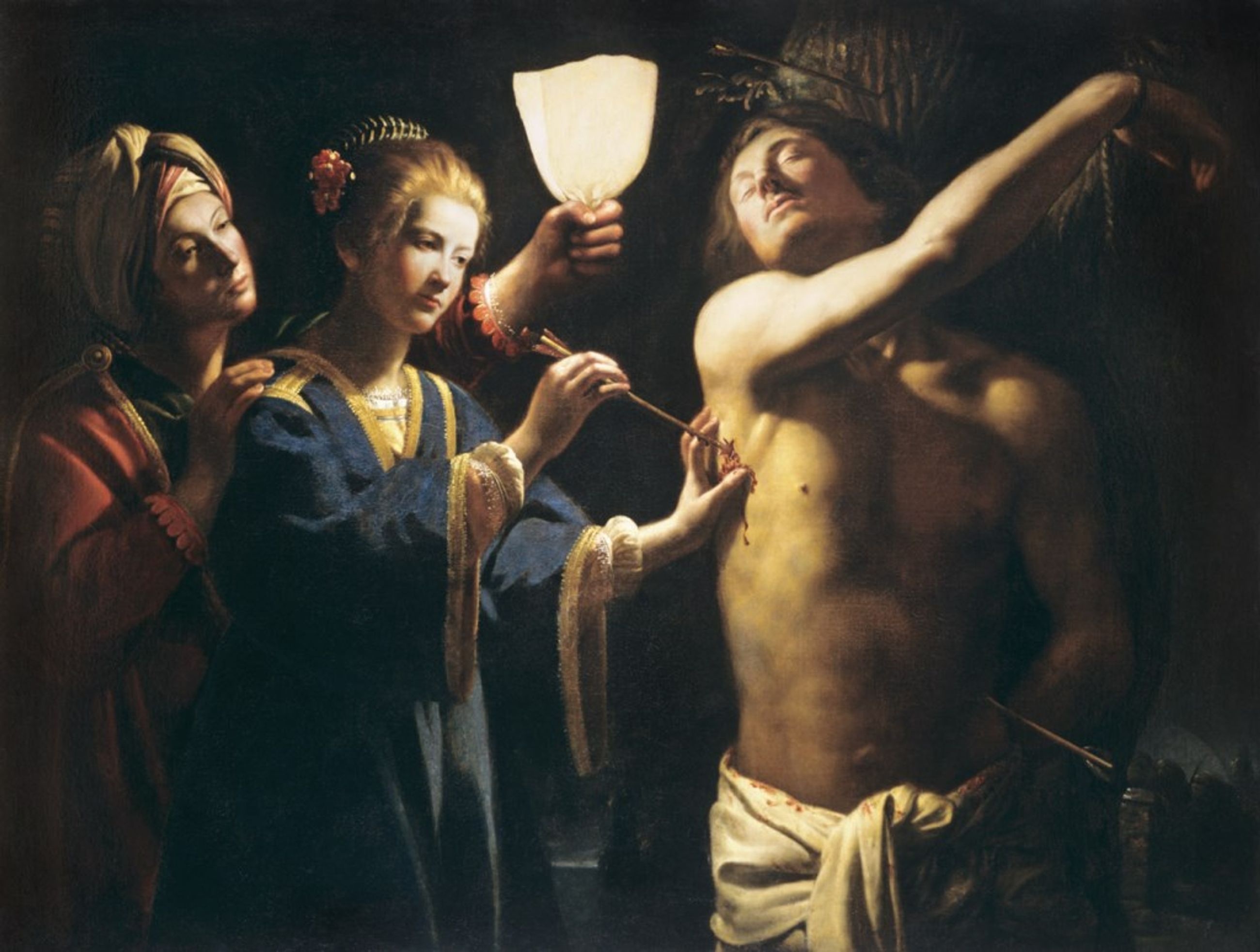 By a shielded flame, a woman draws an arrow from Sebastian’s side while another woman watches and his arm stretches above his head.