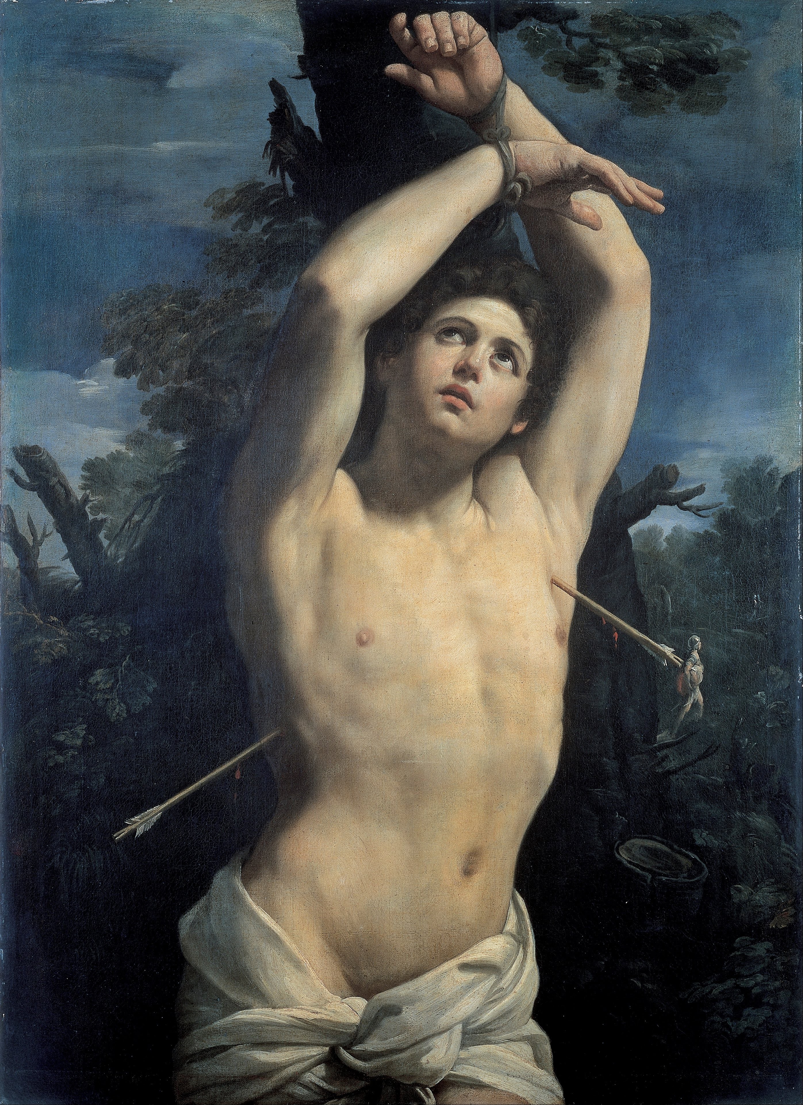 Sebastian looks upward with both wrists bound above his head, two arrows piercing his body against a dark wooded landscape.